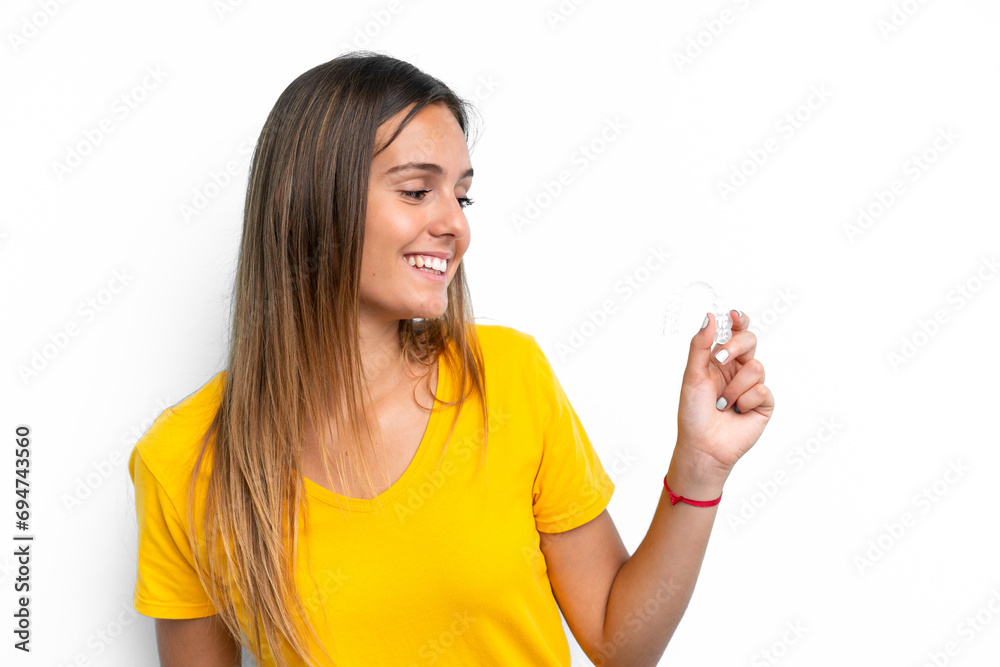 Young caucasian woman holding invisible braces isolated on white background with happy expression Young caucasian woman holding invisible braces isolated on white background with happy expression