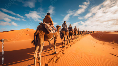 Photograph of tourists reveling in a collective camel ride through the desert.