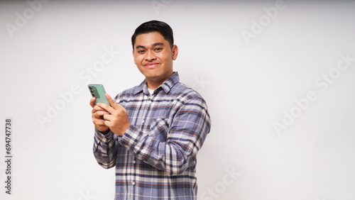 Asian man holding mobile phone showing enthusiastic expression photo