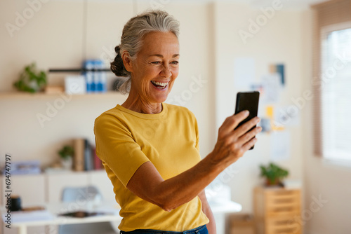 Smiling businesswoman talking on video call through smart phone in office