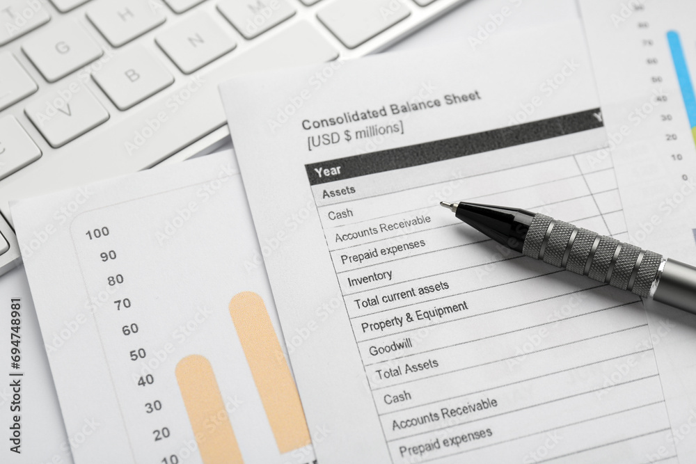 Accounting documents, pen and computer keyboard on white table, closeup
