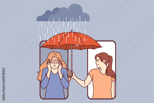 Woman supports upset friend by holding umbrella over girl head who leaning out of phone screen. Concept of mobile applications for providing psychological assistance to upset people