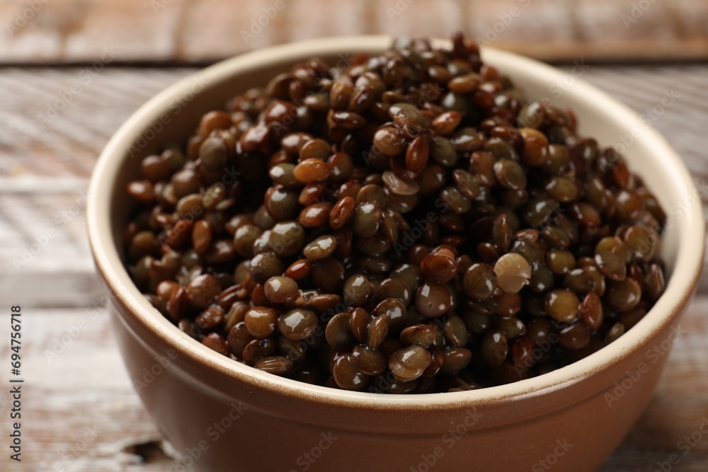 Delicious lentils in bowl on table, closeup Delicious lentils in bowl on table, closeup