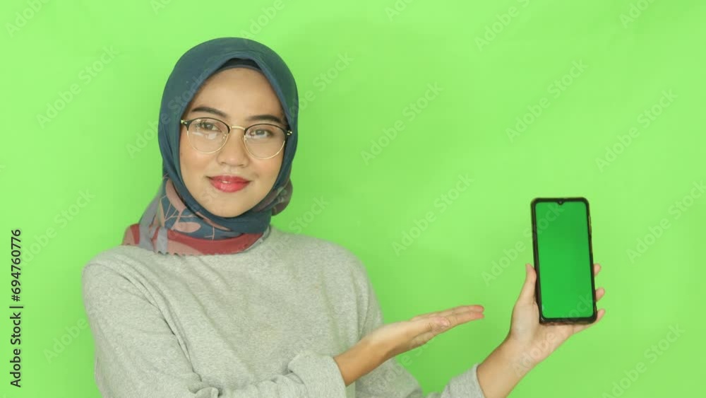 beautiful Asian muslim woman in gray cloth and navy hijab showing green ...
