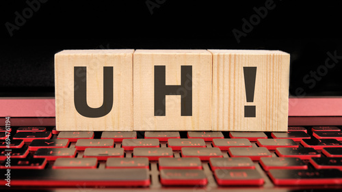 uh written on wooden cubes on the laptop keyboard photo