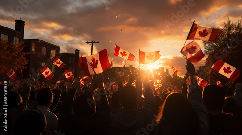 A jubilant crowd waving Canadian flags during a patriotic sunset celebration, cast in silhouette against a vibrant sky.