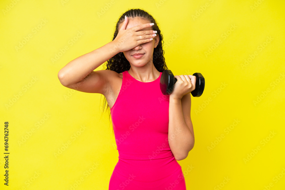 Young sport woman making weightlifting isolated on yellow background covering eyes by hands. Do not want to see something Young sport woman making weightlifting isolated on yellow background covering eyes by hands. Do not want to see something
