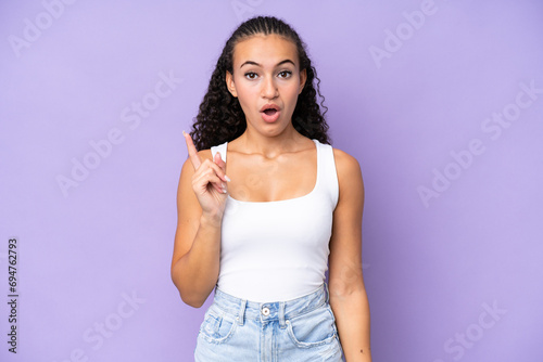 Young woman isolated on purple background intending to realizes the solution while lifting a finger up