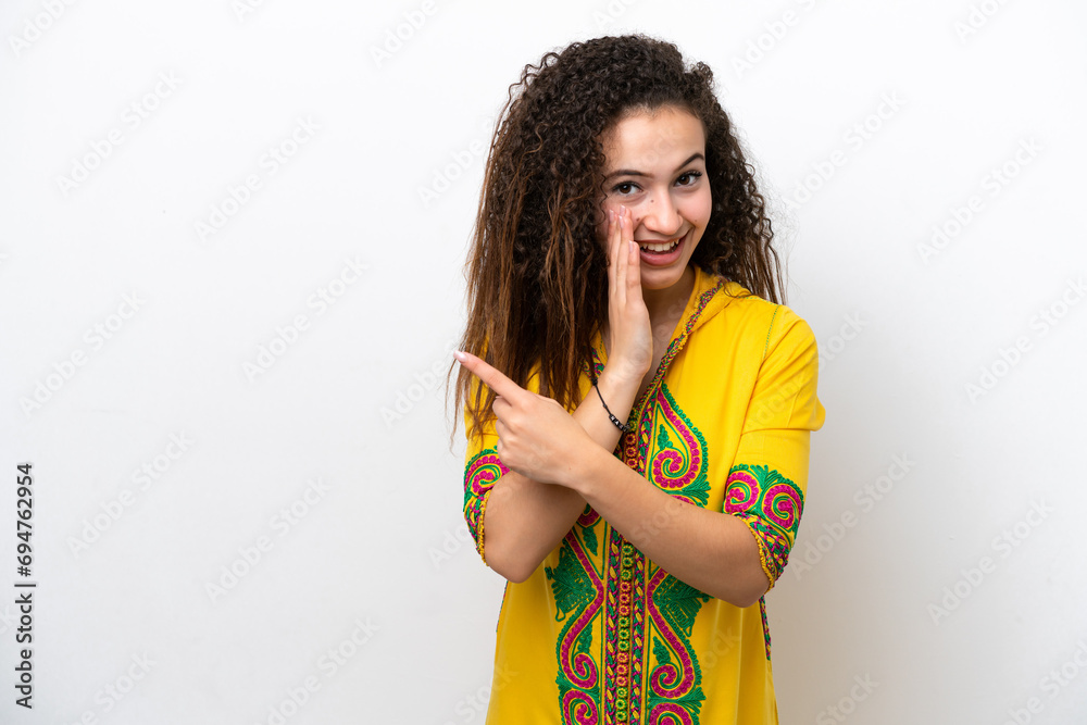 Young Arab woman isolated on white background pointing to the side to present a product and whispering something Young Arab woman isolated on white background pointing to the side to present a product and whispering something