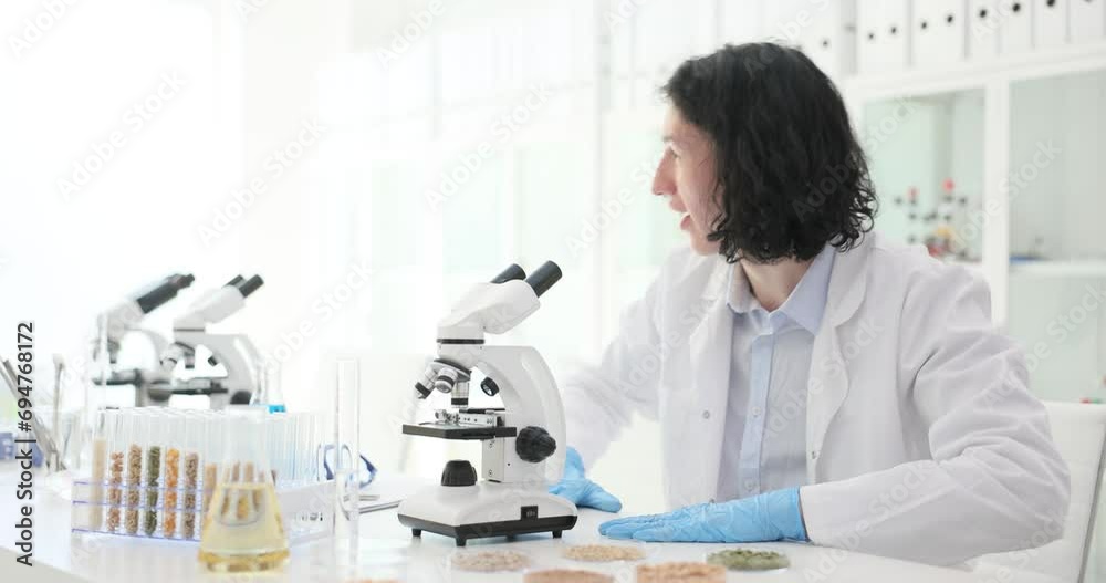 The chemist in the laboratory checks the quality of agricultural seeds, a close-up. Search GMO, data error The chemist in the laboratory checks the quality of agricultural seeds, a close-up. Search GMO, data error