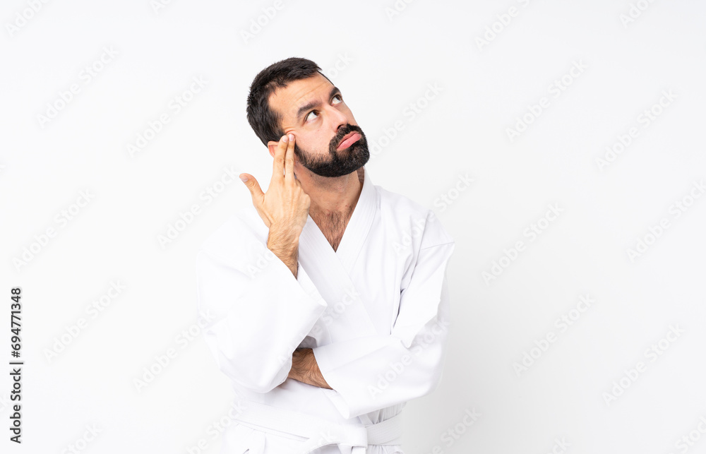 Young man doing karate over isolated white background with problems making suicide gesture Young man doing karate over isolated white background with problems making suicide gesture