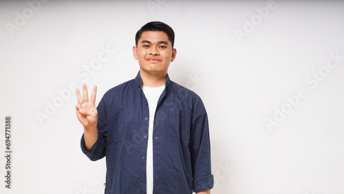 Young Asian man showing tiga fingers sign photo
