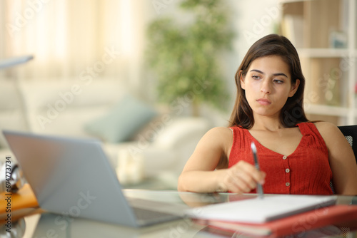 Distracted student waiting looking at laptop