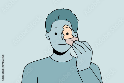 Man tears off fragment of own face to change shell and get rid of psychological problems. Unemotional guy needs self-renewal to improve psychological health and eliminate depressive thoughts