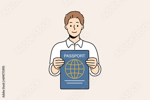 Man with international passport in hands that allows him to travel world and visit countries without obtaining visa. Smiling guy shows passport confirming right to tourism or residence in region