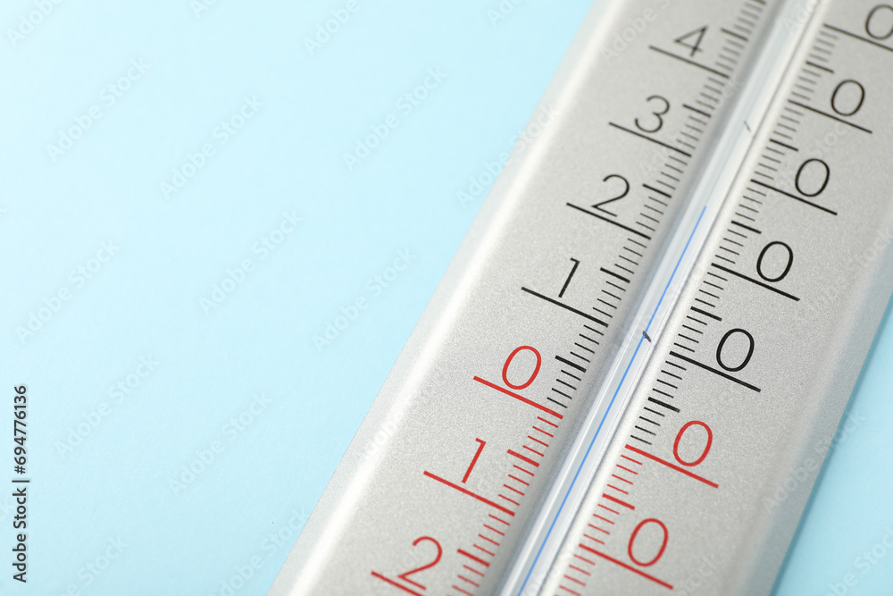Weather thermometer on light blue background, closeup. Space for text Weather thermometer on light blue background, closeup. Space for text