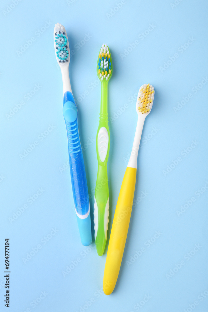 Many different toothbrushes on light blue background, flat lay Many different toothbrushes on light blue background, flat lay