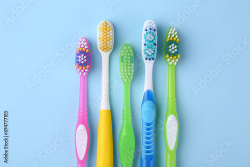 Many different toothbrushes on light blue background  flat lay