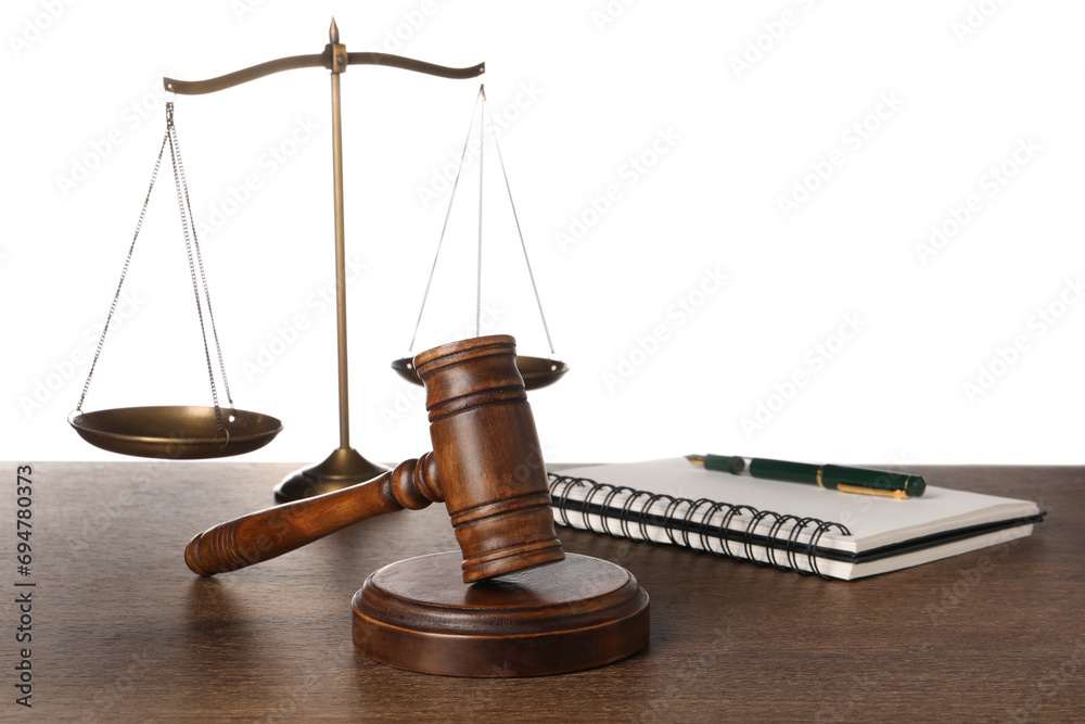 Law concept. Gavel, scales of justice, notebook and pen on wooden table against white background Law concept. Gavel, scales of justice, notebook and pen on wooden table against white background
