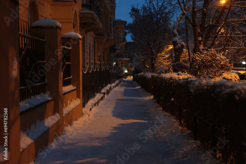 Fototapeta Naklejka Na Ścianę i Meble -  Picturesque view of city street covered with snow in evening