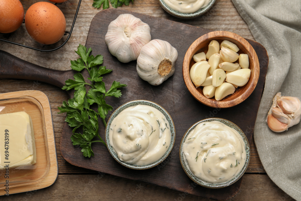 Fototapeta premium Tasty sauce with garlic and ingredients on wooden table, flat lay