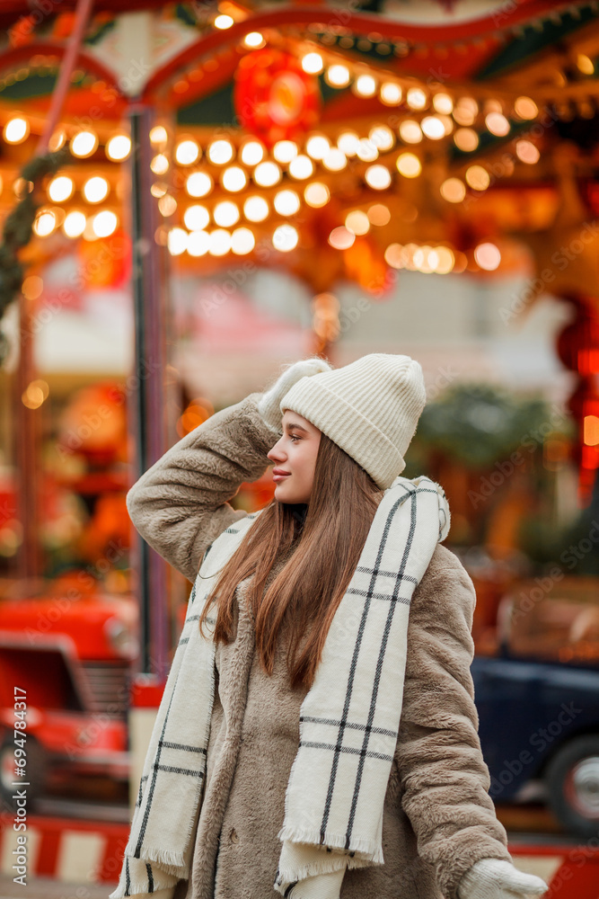 Happy young woman of European appearance at Christmas market in Germany. Festive city. Decor. New Year. Winter vacation.