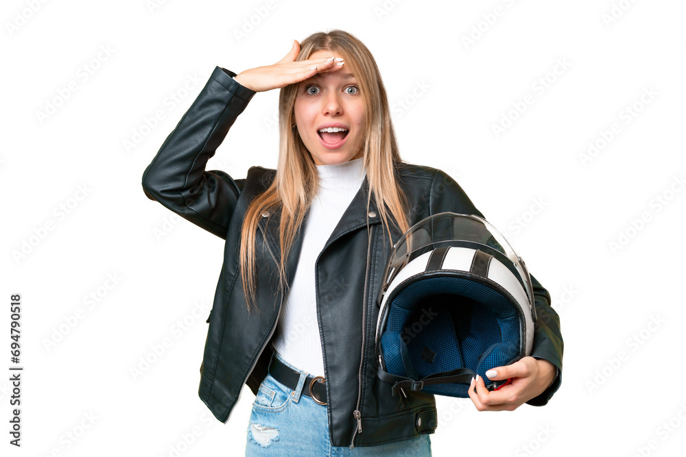 Young pretty blonde woman with a motorcycle helmet over isolated chroma key background doing surprise gesture while looking to the side Young pretty blonde woman with a motorcycle helmet over isolated chroma key background doing surprise gesture while looking to the side