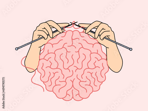 Human brain and hands with knitting needles, as metaphor for intellectual development and attempts to become smarter. Concept self-development and increasing brain capabilities to achieve your goals