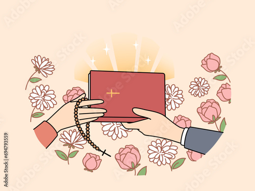 Hands of people with christian bible near flowers, during exchange of religious literature with prayers or gospel. Holy bible with crucifix on cover for those who honor orthodox or catholic faith