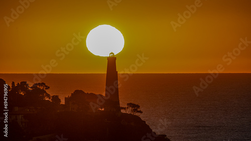 Coucher de soleil en bord de mer sur le phare de la presqu'île du Cap Ferrat depuis le Cap de Nice photo