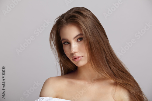 Portrait of elegant young woman over light grey background