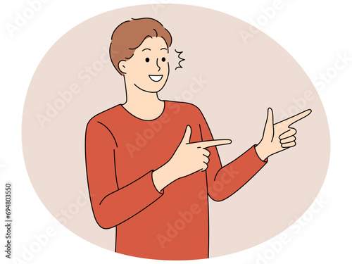 Smiling man point with fingers aside