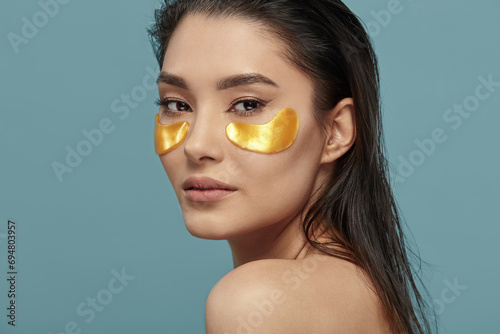 Fototapeta Pretty girl face with hydrating under eye patches.