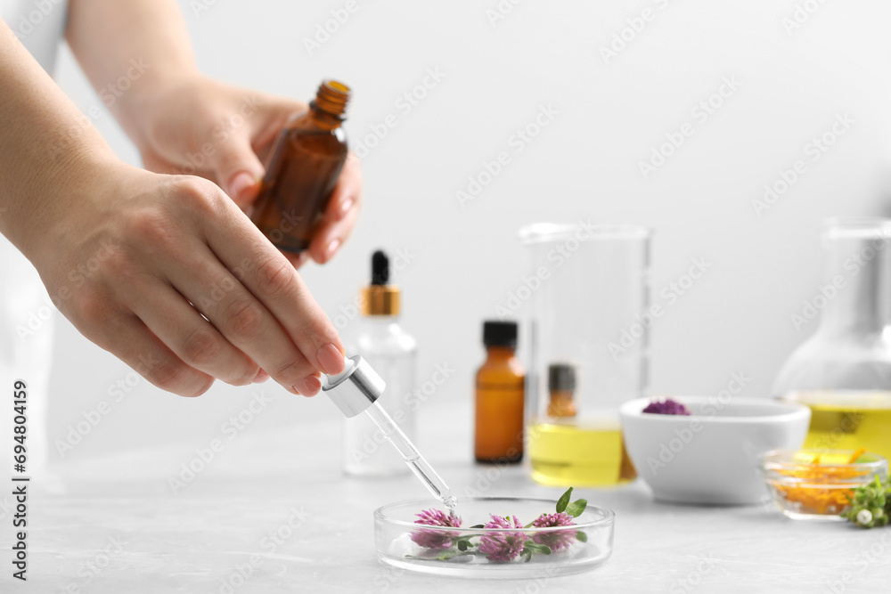 Scientist developing cosmetic oil at light grey table, closeup Scientist developing cosmetic oil at light grey table, closeup