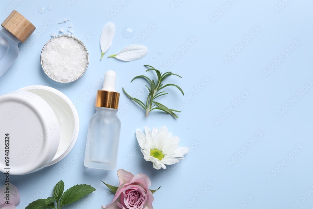 Flat lay composition with bottles of cosmetic serum on light blue background. Space for text Flat lay composition with bottles of cosmetic serum on light blue background. Space for text