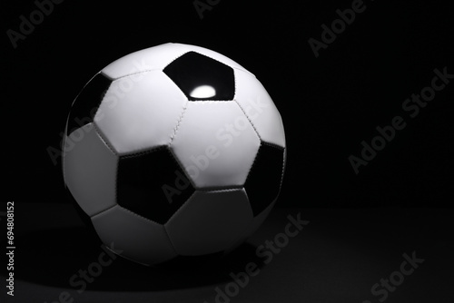 One soccer ball on black background  space for text. Sports equipment