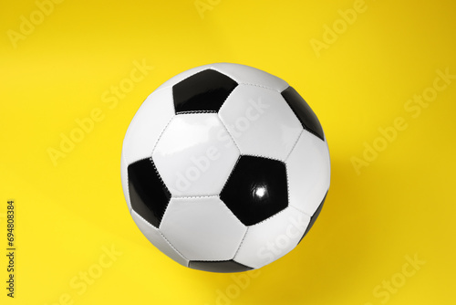 One soccer ball on yellow background  top view. Sports equipment