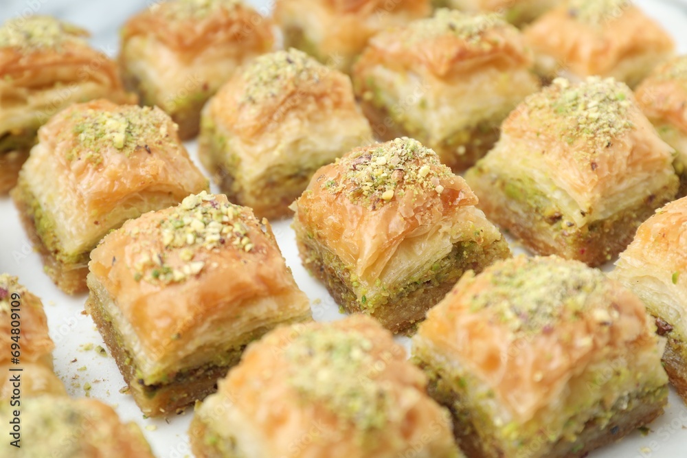 Delicious fresh baklava with chopped nuts on white table, closeup. Eastern sweets Delicious fresh baklava with chopped nuts on white table, closeup. Eastern sweets