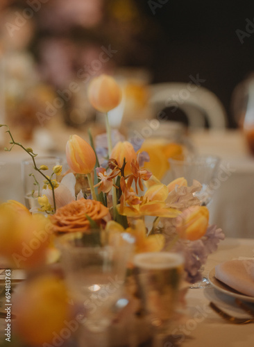 Elegant, romantic table setting for indoor spring wedding reception. Luxury wedding table decoration, special event table set up with fresh spring flowers arragements. photo