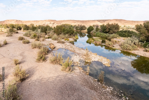 Low scattered clouds are reflected in the Fish River in Southern Namibia