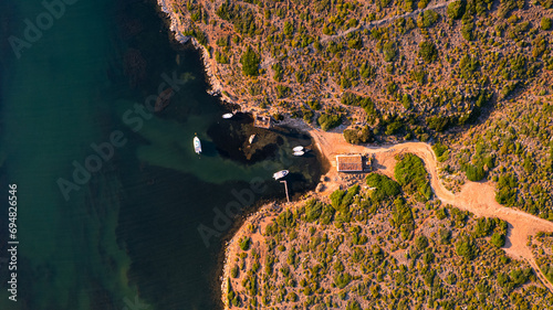 Aerial view of Sanitja natural port in Menorca with winding road along a rugged coastline photo