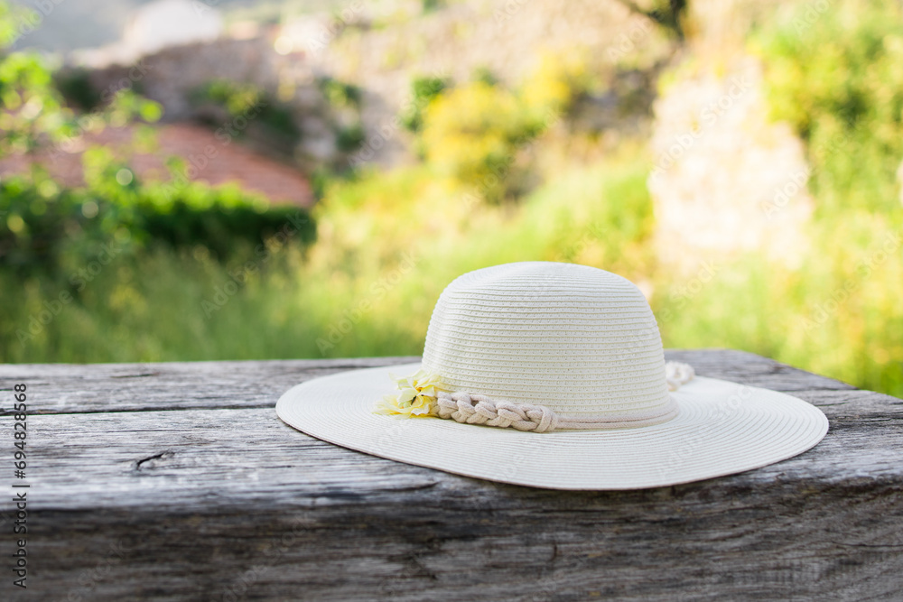 Summer nature background. Braided straw hat on bench in garden. spring season. Rustic composition nature. Relax voyage time. Copy space and mock up place for text Summer nature background. Braided straw hat on bench in garden. spring season. Rustic composition nature. Relax voyage time. Copy space and mock up place for text