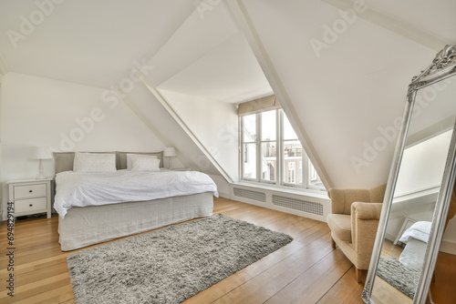 White loft bedroom with with mirror and window photo