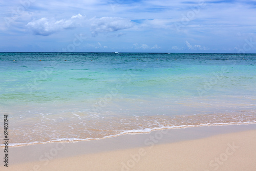 Travel background with soft wave of blue ocean on sandy beach.