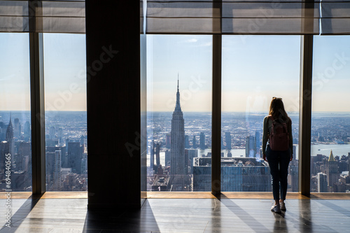 Woman overlooking Manhattan, New York with empire State building photo
