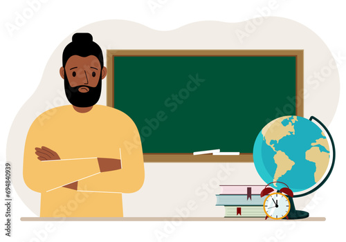 Male teacher near the blackboard. The concept of education, teaching, teacher's day.