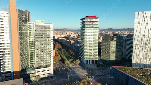 Aerial view of Barcelona at midday with high skyscrappers and wide panorama of the city on the background. Landscape and architecture. Drone flying over Forum Park and Diagonal Mar. Spain, Europe. photo