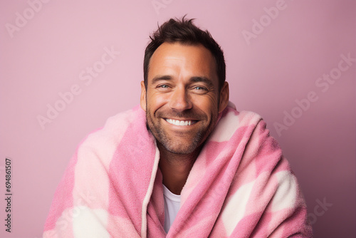 Generative ai photo of handsome positive man wrapped in warm blanket isolated on pink color background