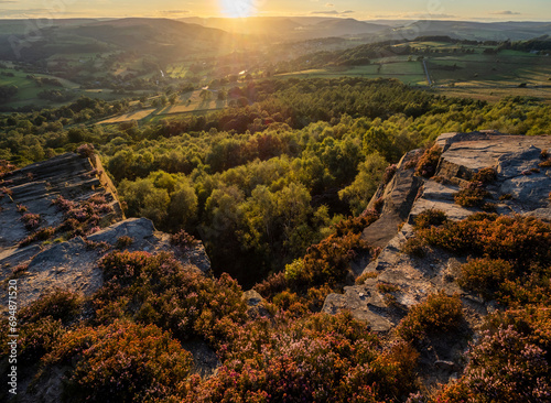 View looking towards Hathersage and Hope Valley in evening sunlight from Millstone Edge with blooming heather, Peak District National Park, Derbyshire, England photo