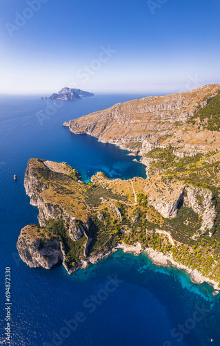 Panoramic view of the rocky shore of Punta Campanella and Ieranto Bay with Capri island in the background, Amalfi Coast, Naples province, Campania region, Tyrrhenian Sea, South of Italy photo